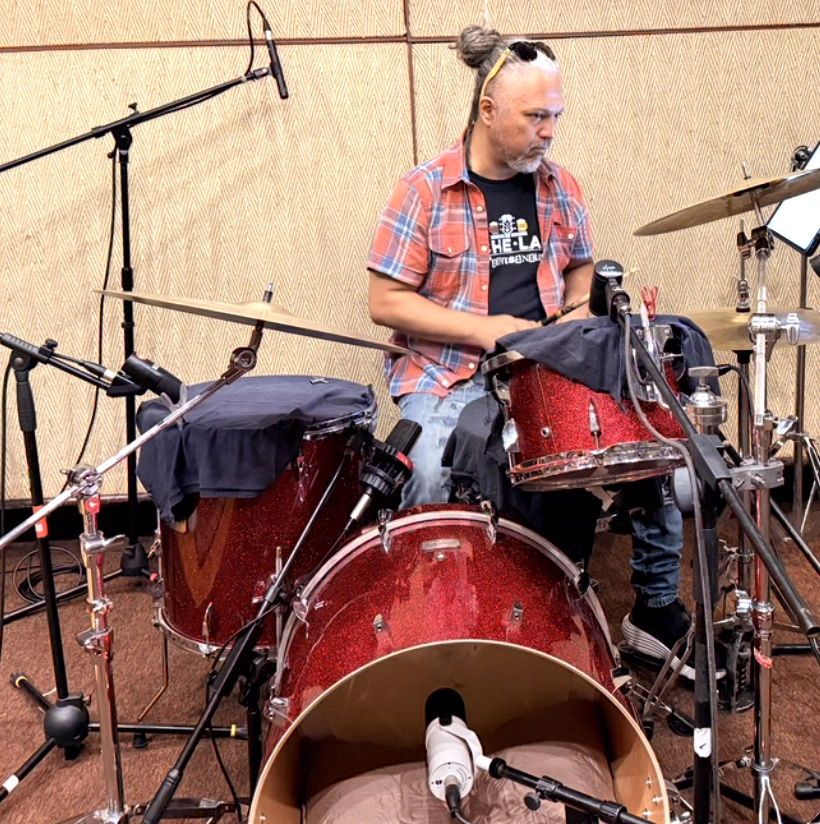 Chejo Enríquez detrás del kit rojo en la sala de Phantom Records, con los tambores amortiguados y el bombo microfoneado por dentro