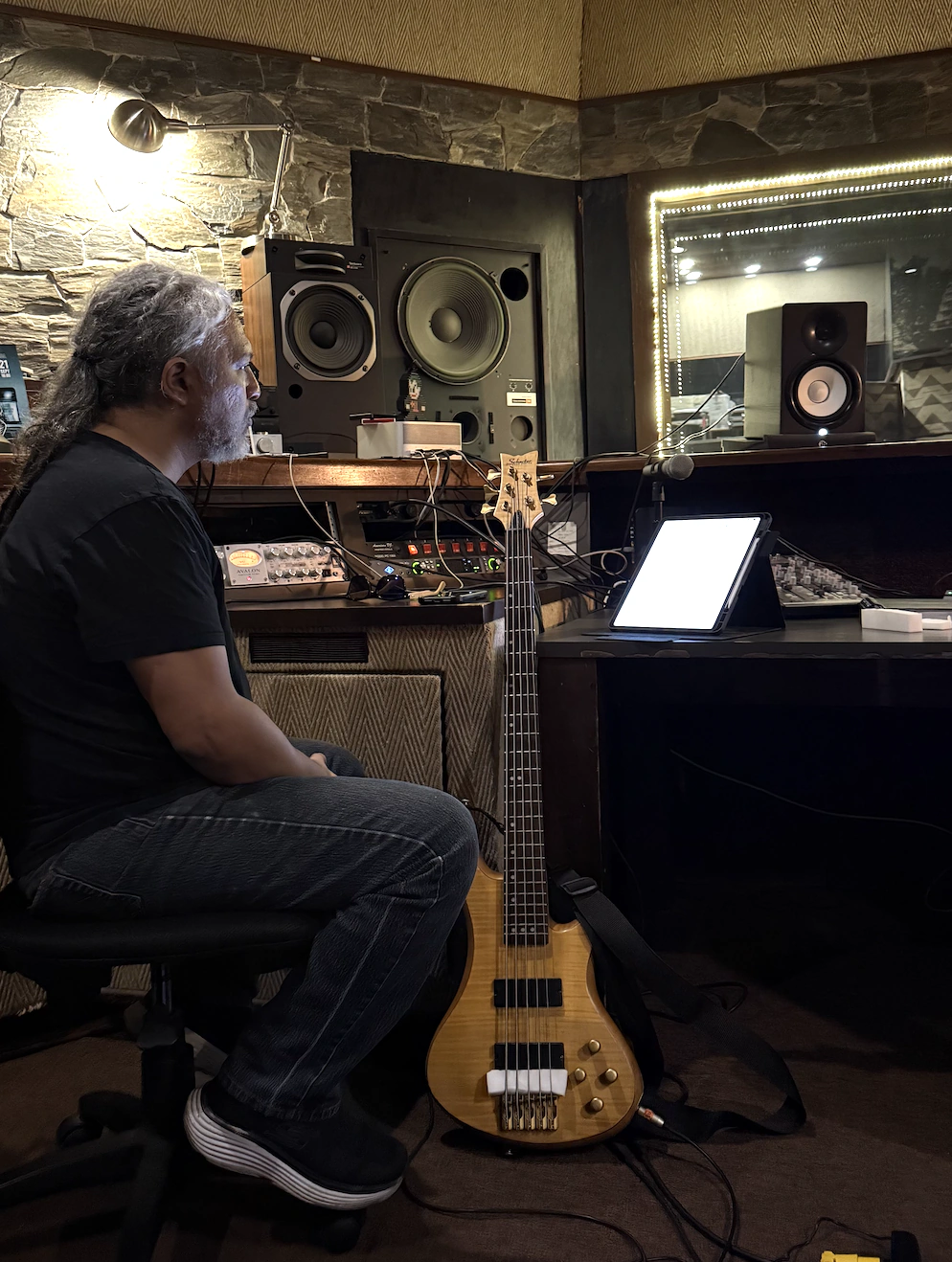 Chejo Enríquez en el control room de Phantom Records junto a su bajo de cinco cuerdas y el chart en el iPad