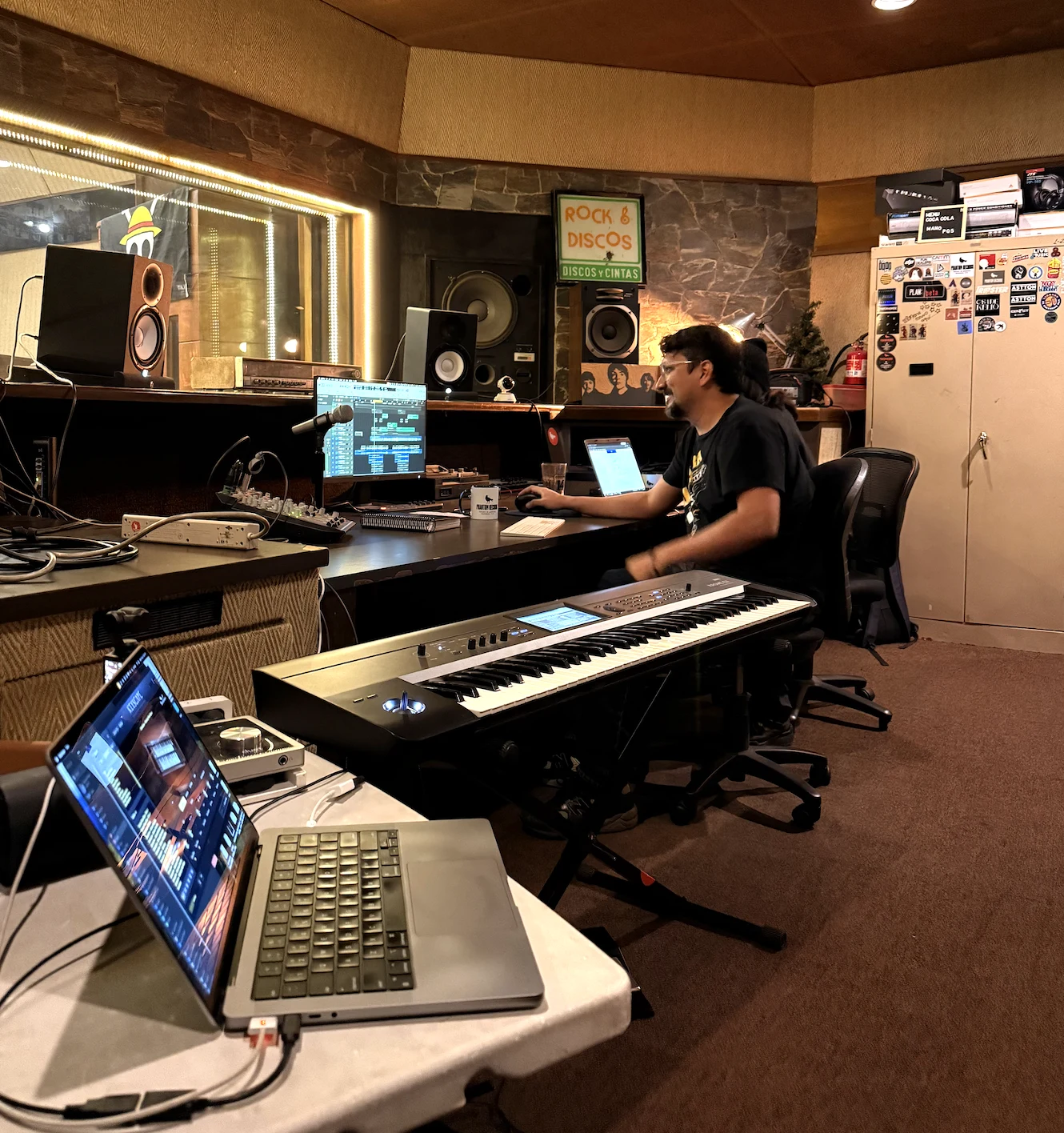 David Chinchilla trabajando frente a la sesión de Logic en el control room de Phantom Records, con un teclado, dos computadoras y la consola del estudio