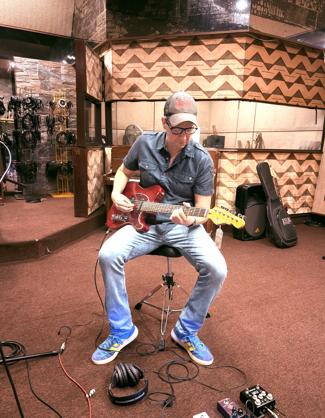 Jorge Lambour tocando una guitarra G&L roja durante la grabación de En La Piel en Phantom Records, con sus dos pedales al frente